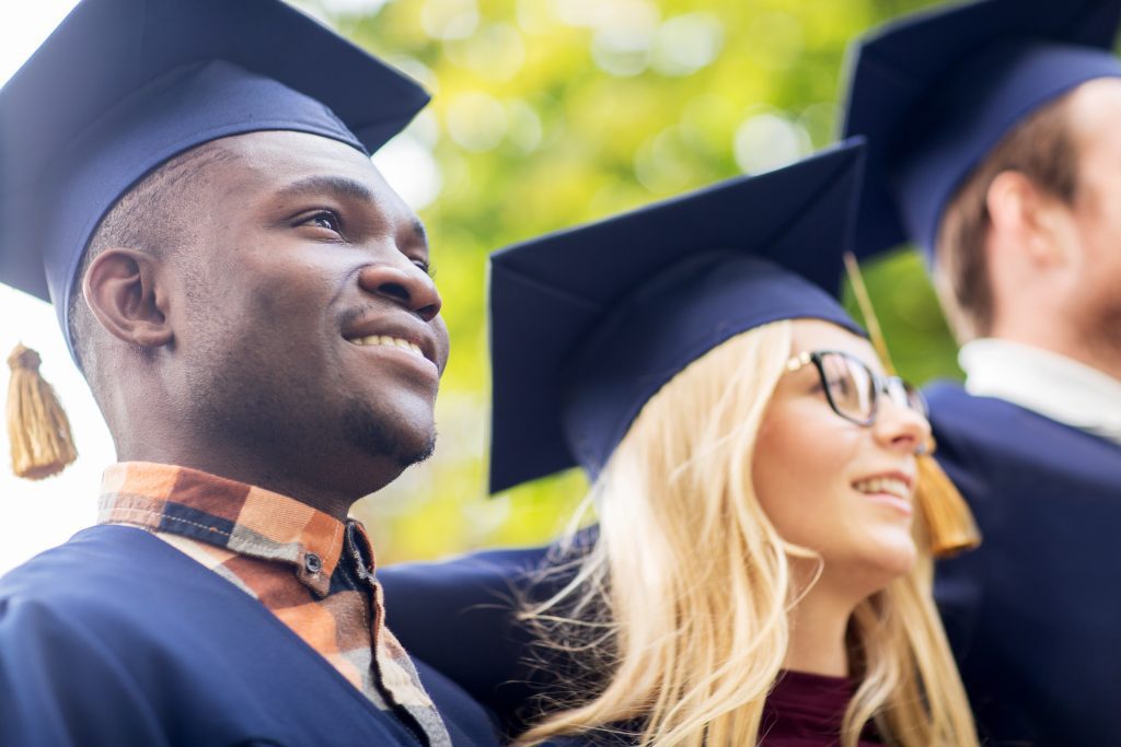 happy students or bachelors in mortar boards