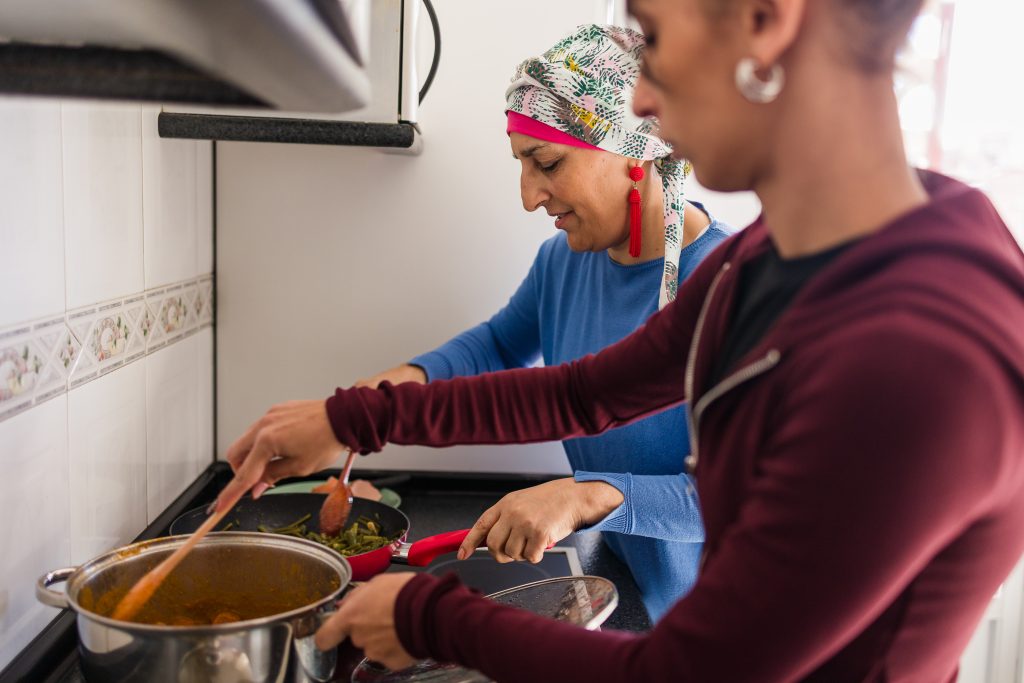 Mother with cancer and daughter cooking healthy meal